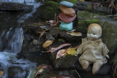 matt_garber_still_life_baby_doll_stack_stones_nature_depth_of_field_water_flow