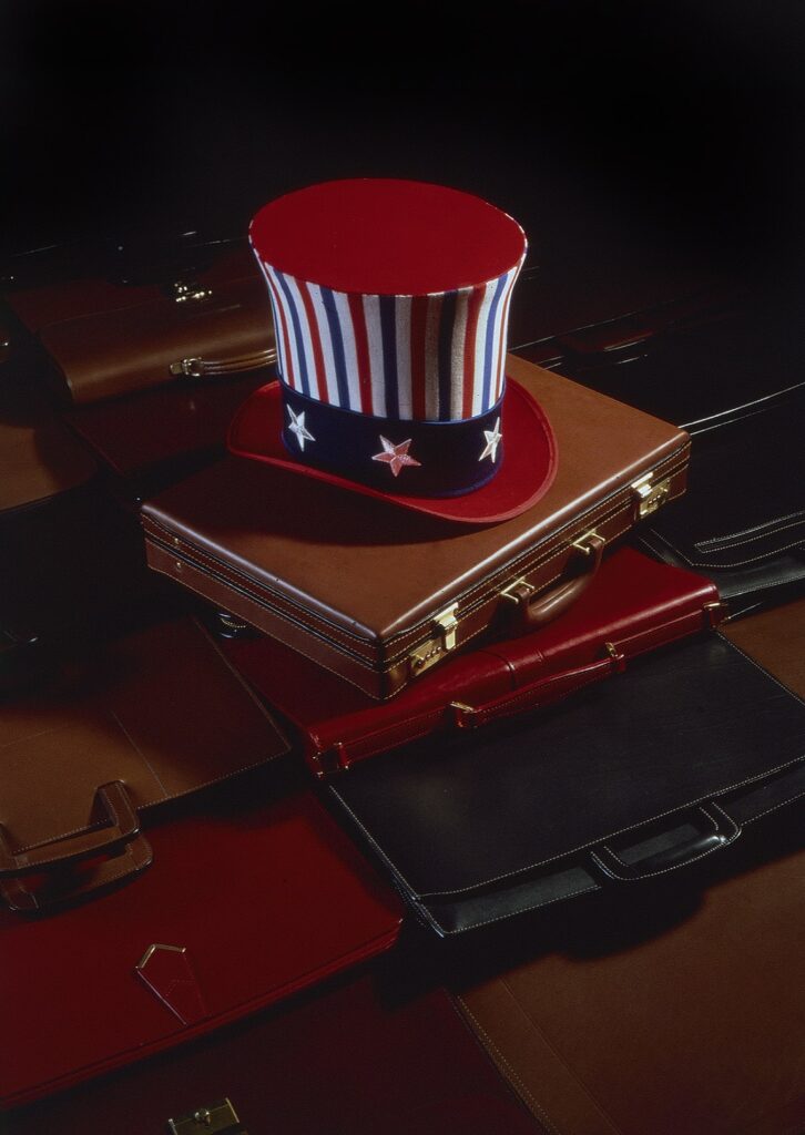 still life of Uncle Sam top hat with executives briefcases